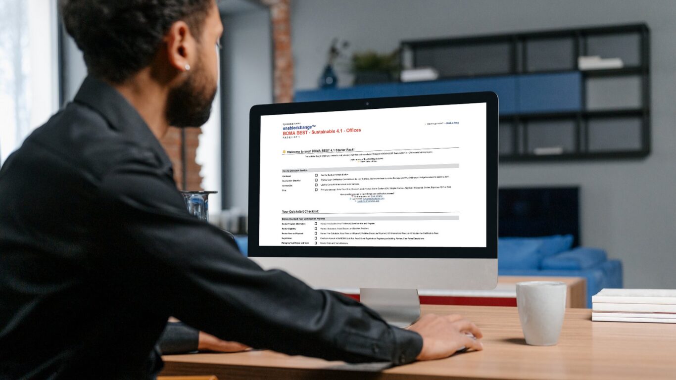 Person in an office space reviewing the BOMA BEST Sustainable Starter Pack on their desktop computer display.